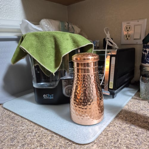 Customer's hammered copper Himalayan Ayurvedic Bedside Carafe sitting on a kitchen counter.
