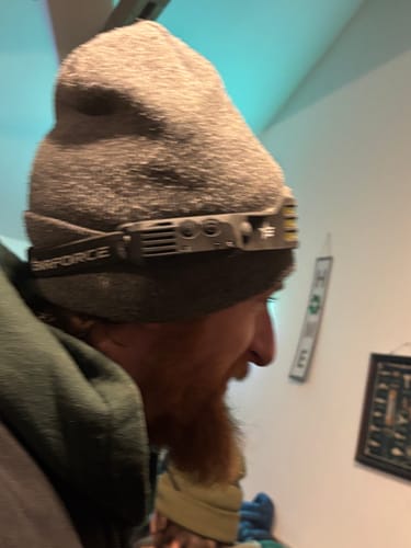 Customer wearing the LED Headlamp 2.0 on a gray beanie, viewed from the side.