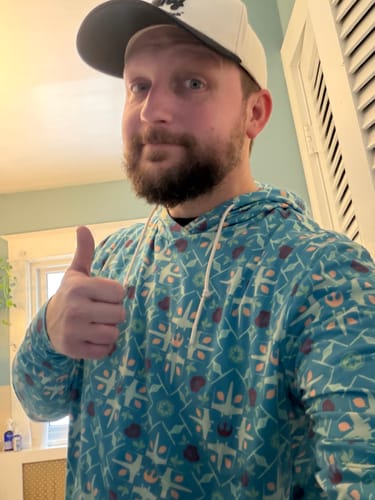 Reviewer gives a thumbs-up while wearing the patterned Grand Maz Couch Performance Hoodie.