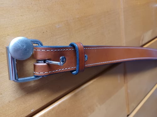 Close-up of a customer's The Gunner Stitched belt in Oak, highlighting the sturdy leather and stainless steel buckle.