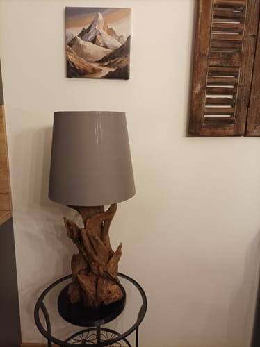 Bewertung eines Kunden: Die Wurzelholz-Tischlampe mit rustikalem Fuß und grauem Schirm auf einem Beistelltisch.