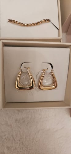 Close-up of reviewer's gold-colored Marly Earrings in their presentation box.
