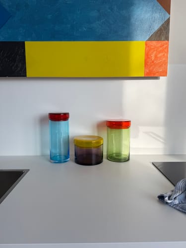 Recensent toont drie kleurrijke POLSPOTTEN voorraadpotten op een strak keukenblad.