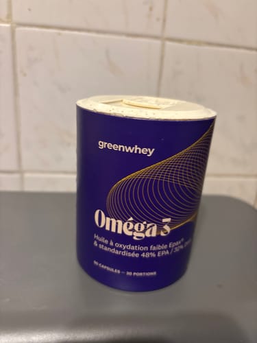 Le pot en carton bleu d'Oméga 3 EPAX® d'un client, posé sur un comptoir.