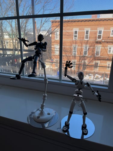 Customer's black and white Stickybones figures from the Send-It-Now Bundle in dynamic poses on a windowsill.