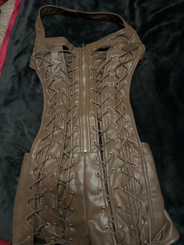Customer's brown, lace-up Vice Body bodysuit shown laid flat on a dark surface.