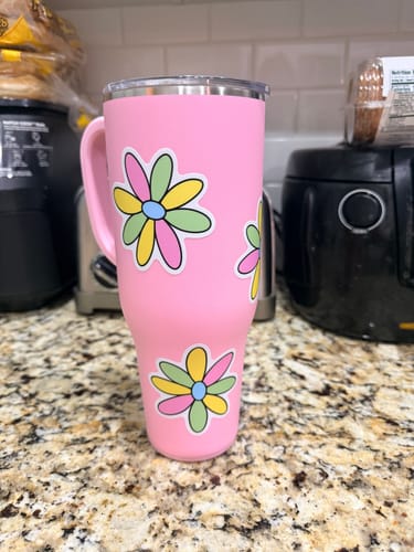 Customer's pink tumbler decorated with several Multicolor Daisy Aesthetic Stickers.