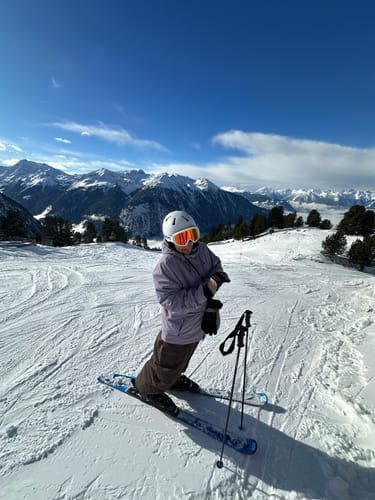Reviewer skiing on a sunny mountain in the baggy, grey Face Vented Snow Jacket.