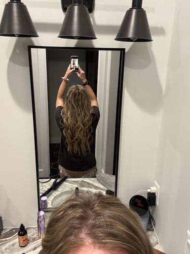 Customer from behind showing their long, wavy hair after installing the Butterfly Weft Extensions in Balayage Brown.
