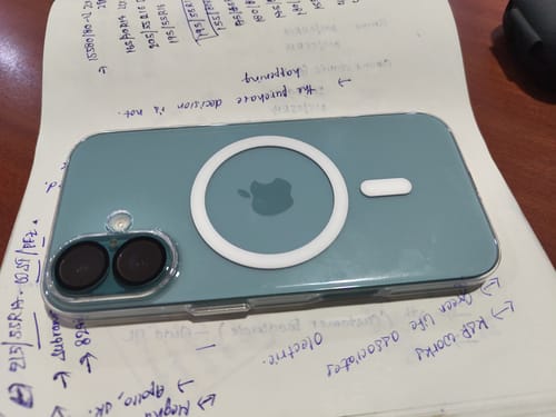Reviewer's clear Anti Yellow Magsafe case on a green iPhone, showing the white magnetic ring.