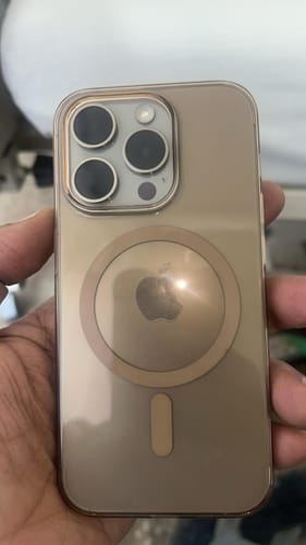 Customer holding an iPhone 15 Pro with the sleek Anti-Yellow Magsafe Clear Case in Crystal Desert Titanium.