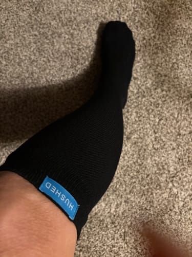 Customer wearing a black Performance Eucalyptus Compression Sock, showing the fit on their lower leg and ankle.