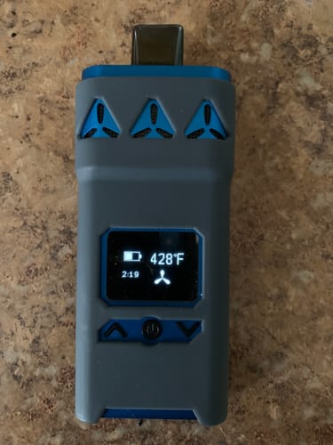 Customer's blue AirVape X inside its grey protective cover, turned on and displaying a temperature of 428°F.