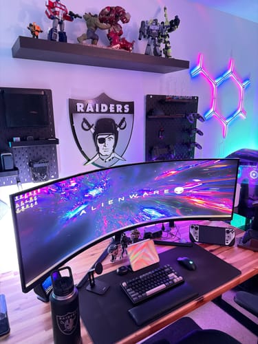 Customer's Raiders vintage shield wall art mounted above a monitor in a gaming setup.