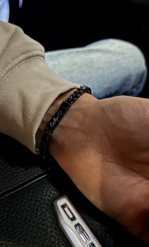 Close-up of a customer wearing the black, engraved Franco Link Bracelet on their wrist.