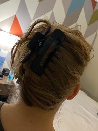 Reviewer from behind showing a black cloud clip holding their light brown hair in an updo.