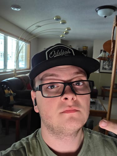 Reviewer wearing the black Big Unstructured A-Frame Hat in a selfie, showing its comfortable fit.