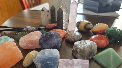 Customer's colorful collection of crystals from the VIP Crystal Club displayed on a wooden table.