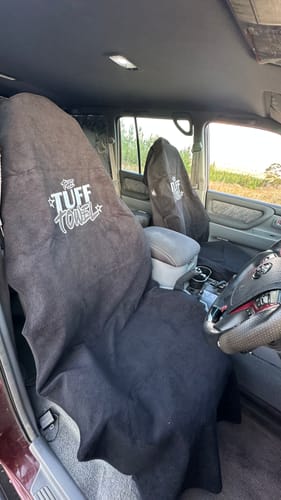 Customer's two black Waterproof Car Towel Seat Covers draped over the front seats inside a car.