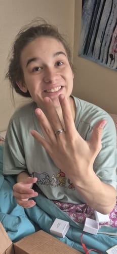 Customer smiling and showing the Hug From Heaven Ring on their finger.