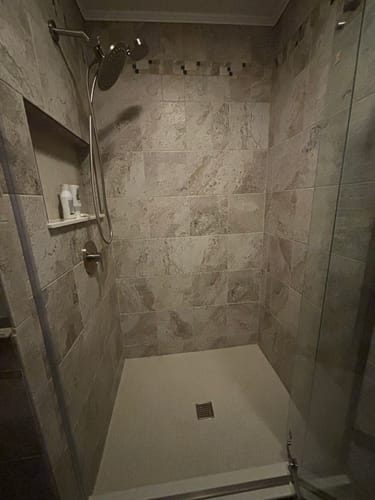 Customer's new shower valve and trim kit installed in a beige, tiled shower stall.