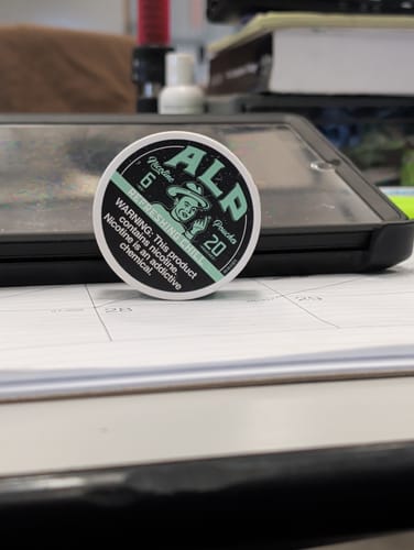 Customer's can of Refreshing Chill Nicotine Pouches resting on a desk calendar.