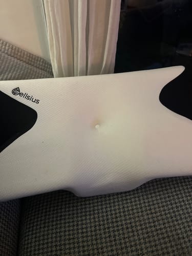 Le coussin orthopédique pour genoux Cellsius d'un client, posé sur une surface texturée.
