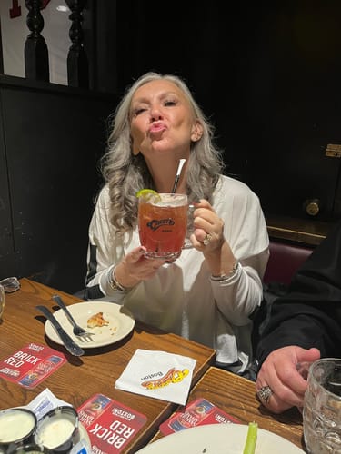 Reviewer at a restaurant, showing her clear skin after using the Micro Infusion System.