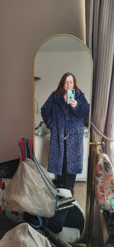 Reviewer taking a mirror selfie wearing the navy leopard longline faux fur coat.