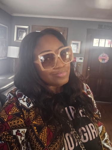 Customer taking a selfie indoors while wearing the colorful Vivian African Print Quilted Bomber Jacket.