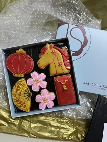 Customer's open Chinese New Year Biscuit Box displaying colorful biscuits shaped like a horse, lantern, and flowers.