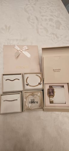 Reviewer's elegant gift packaging shown with a watch and jewelry ready to be wrapped.