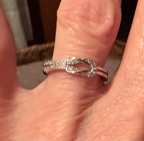 Close-up of a customer wearing the sparkling We Will Link Again Knot Ring.