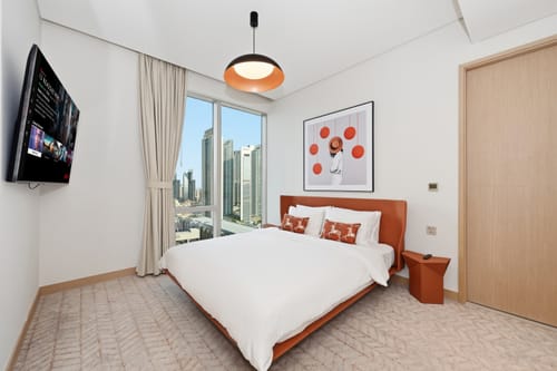 Customer's Verona Orange King Size Bed in a bright, modern bedroom with a city view from the window.