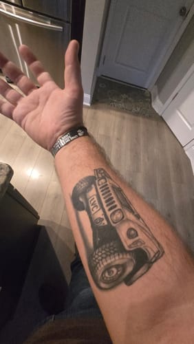Reviewer showing the perfect fit of their custom black bracelet on their arm, next to a tattoo.