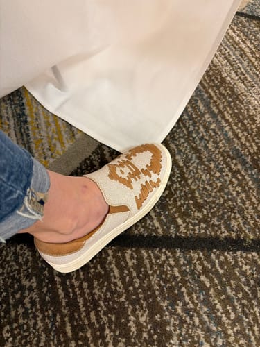 Reviewer's foot wearing the tan Marian Slip On Sneaker, highlighting the woven Aztec-style pattern.