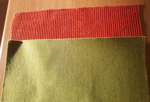 Customer's green self adhesive felt sheet shown with a piece of red corduroy fabric.