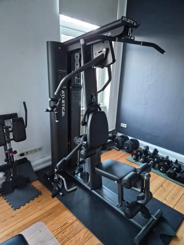 Rezensent zeigt die aufgebaute, schwarze Kraftstation Type_5_Weights_25kg in einem Zimmer.