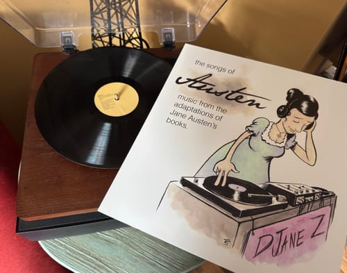 Customer's custom vinyl record and personalized album sleeve with cartoon artwork, displayed on a wooden turntable.