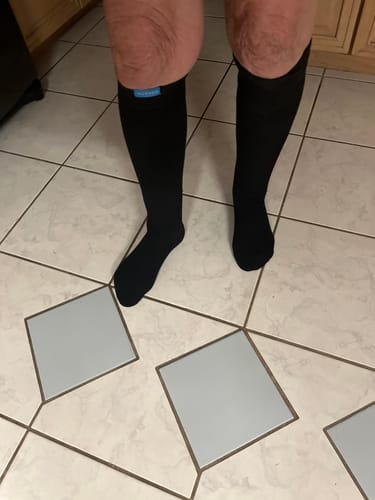 Customer standing on a tiled floor wearing the black Performance Eucalyptus Compression Socks.