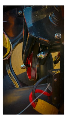 Close-up of a reviewer's Stock Fork Belt Drive Conversion Kit installed, showing the red pulley.