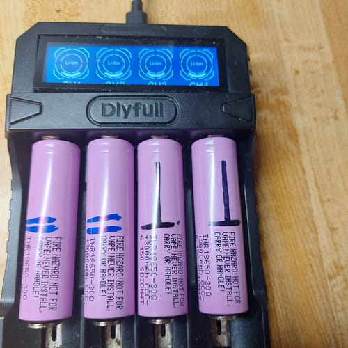 Customer's four pink Samsung 30Q 18650 batteries sitting inside a black multi-bay charger.