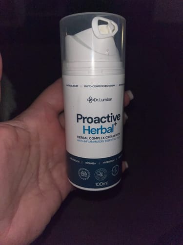 Egy vásárló a kezében tartja a fehér Proactive Herbal+ krémet.
