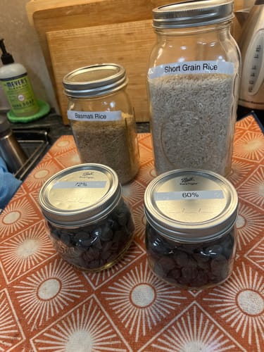 Customer's four vacuum-sealed mason jars filled with rice and chocolate chips on a kitchen counter.
