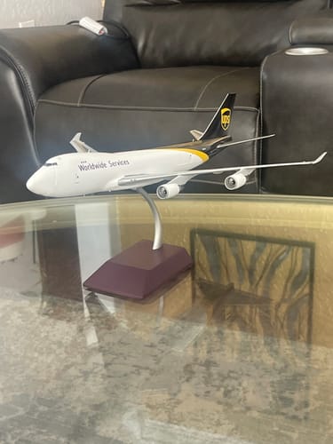 Reviewer's detailed GEMINI200 UPS 747-400FSCD model on its stand, displayed on a glass table.
