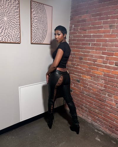 Reviewer showing the back of the black Vice Pant, highlighting the full-length lace-up design down the legs.