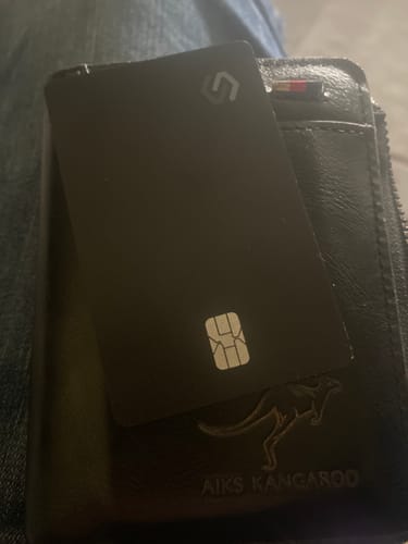 Reviewer shows their black SPOTMINDERS. Tracking Card PRO placed inside a black leather wallet.