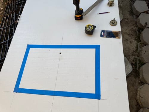 Customer's white door marked with blue tape, preparing to cut an opening for the glass and frame kit.