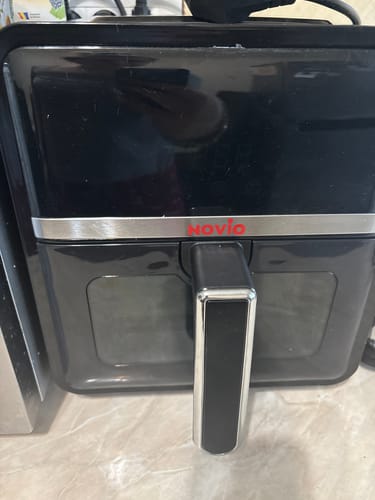 Friteuza cu aer cald Novio StonePro a unui client, de culoare neagră, așezată pe un blat de bucătărie.