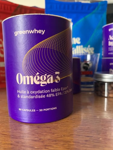 Avis d'un client : gros plan sur le pot violet d'Oméga 3 EPAX® posé sur une table en bois.